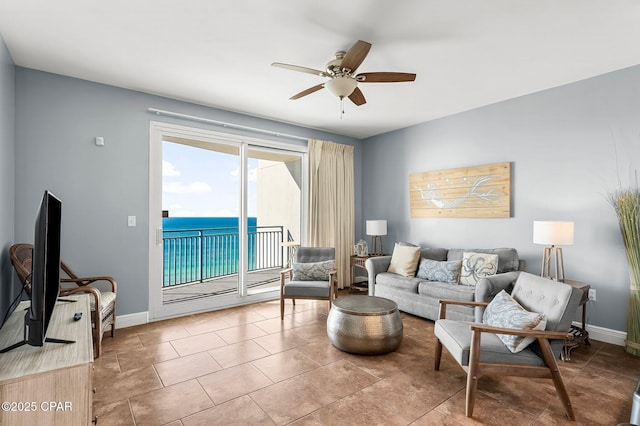 living area featuring tile patterned flooring, baseboards, and ceiling fan