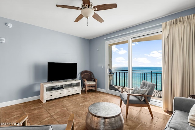 tiled living room featuring ceiling fan and baseboards