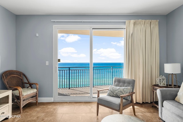 living area featuring baseboards and a water view