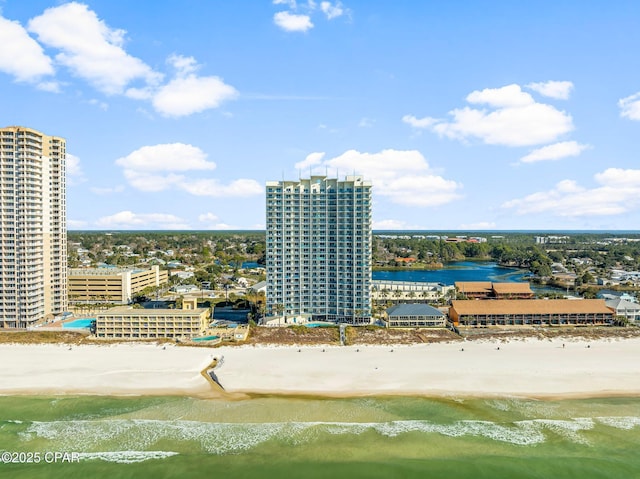 drone / aerial view with a city view, a view of the beach, and a water view