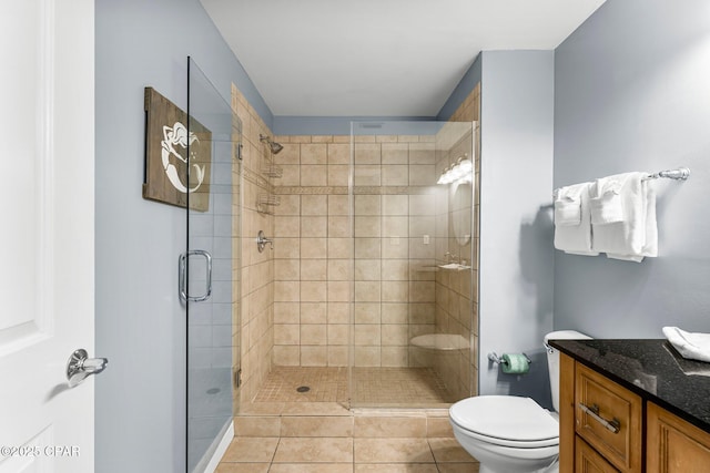 bathroom featuring vanity, a shower stall, toilet, and tile patterned flooring