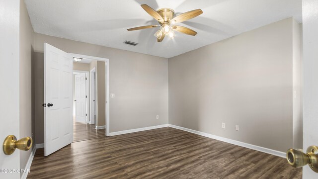 unfurnished room featuring ceiling fan and dark hardwood / wood-style floors