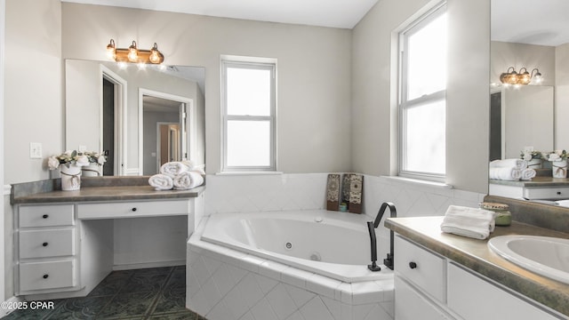 bathroom featuring tile patterned flooring, vanity, and tiled bath