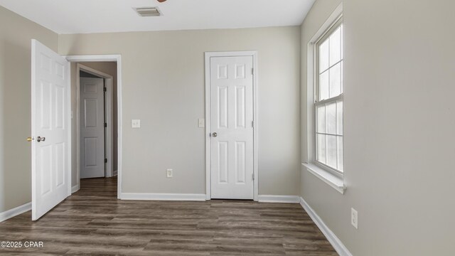 unfurnished bedroom featuring dark wood-type flooring