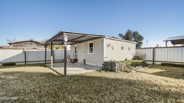 rear view of house featuring a lawn, a patio area, and a fenced backyard