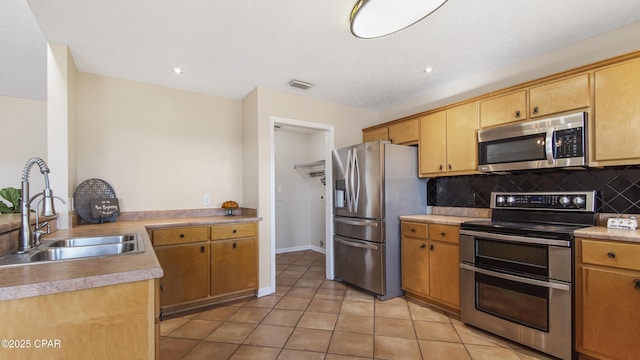 kitchen featuring light tile patterned flooring, sink, stainless steel appliances, and tasteful backsplash