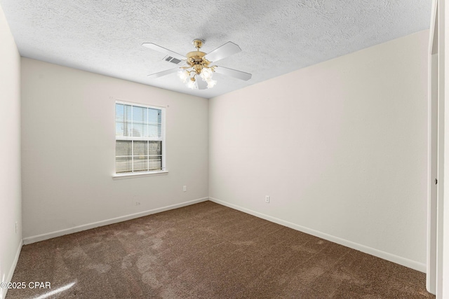 spare room with ceiling fan, a textured ceiling, and dark carpet