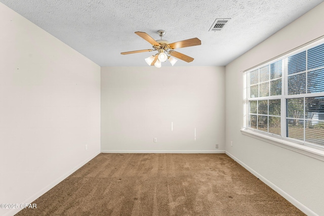 carpeted spare room featuring ceiling fan and a textured ceiling