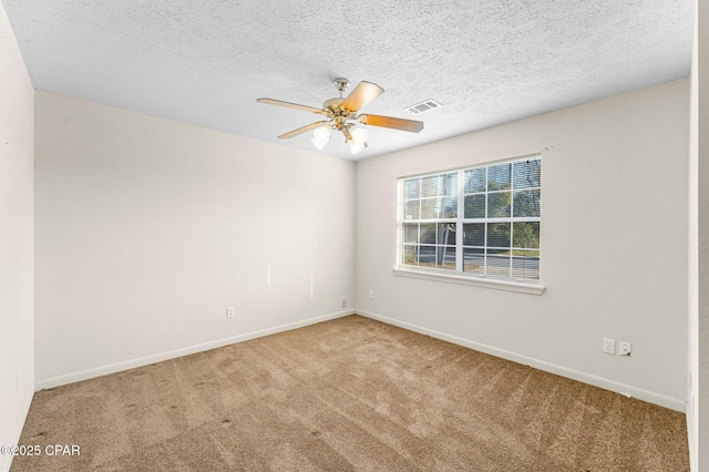 carpeted spare room featuring a textured ceiling and ceiling fan