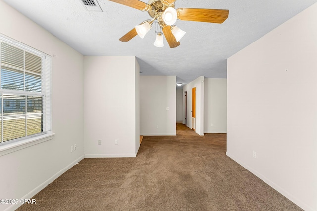 carpeted empty room featuring ceiling fan and a textured ceiling