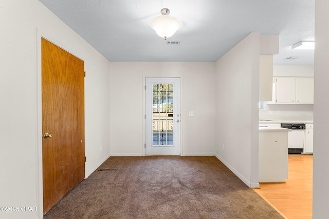 doorway to outside with light colored carpet