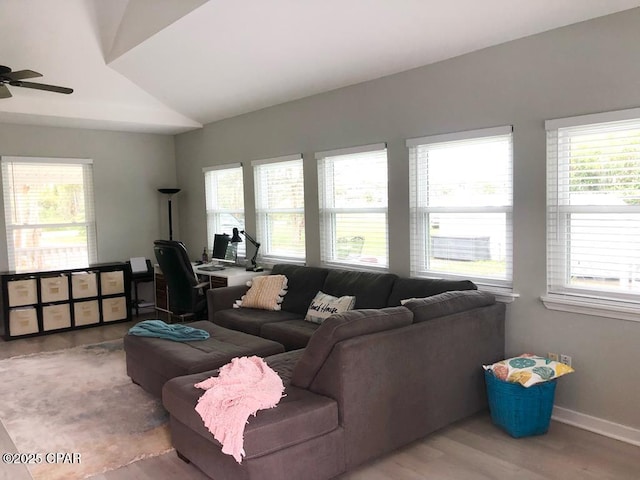 living room featuring a wealth of natural light, ceiling fan, wood-type flooring, and lofted ceiling