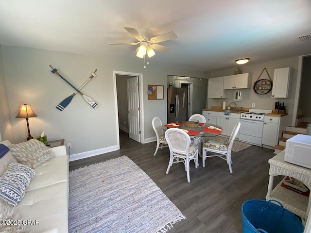 dining room with dark hardwood / wood-style floors, ceiling fan, and sink