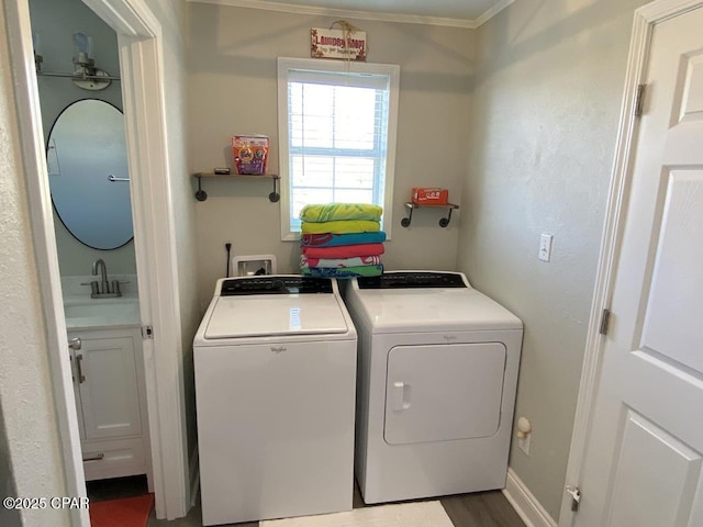 washroom featuring hardwood / wood-style flooring, separate washer and dryer, sink, and ornamental molding