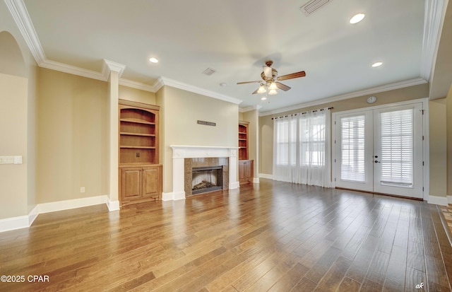 unfurnished living room with hardwood / wood-style flooring, ornamental molding, ceiling fan, and a high end fireplace