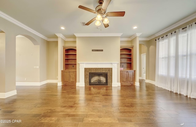 unfurnished living room featuring crown molding, ceiling fan, a fireplace, and hardwood / wood-style floors