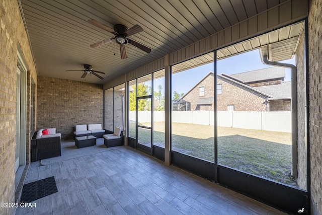 unfurnished sunroom with ceiling fan