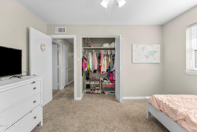 bedroom featuring ceiling fan, light carpet, and a closet