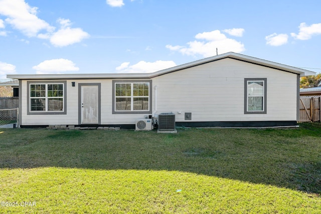 rear view of property featuring ac unit, a lawn, and central air condition unit