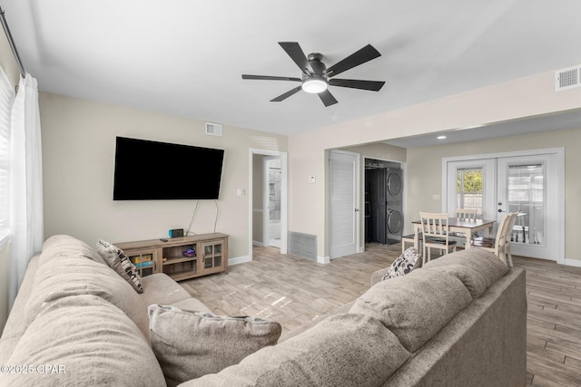 living room featuring french doors, ceiling fan, and light wood-type flooring