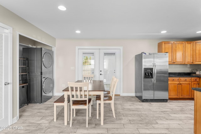 kitchen featuring stacked washer / dryer, french doors, and stainless steel fridge with ice dispenser