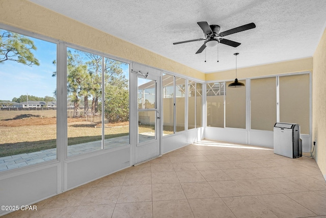 unfurnished sunroom featuring ceiling fan