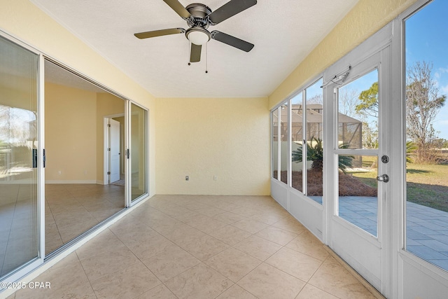 unfurnished sunroom featuring ceiling fan