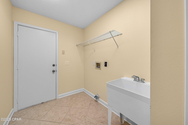 laundry area featuring washer hookup, light tile patterned flooring, and sink