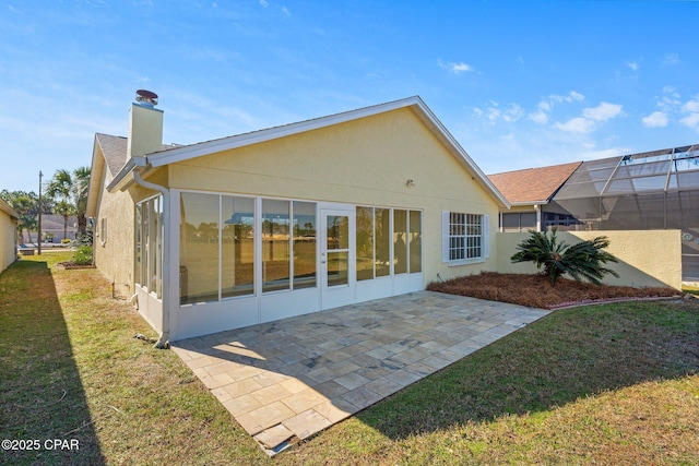 rear view of house featuring a lawn, a lanai, and a patio