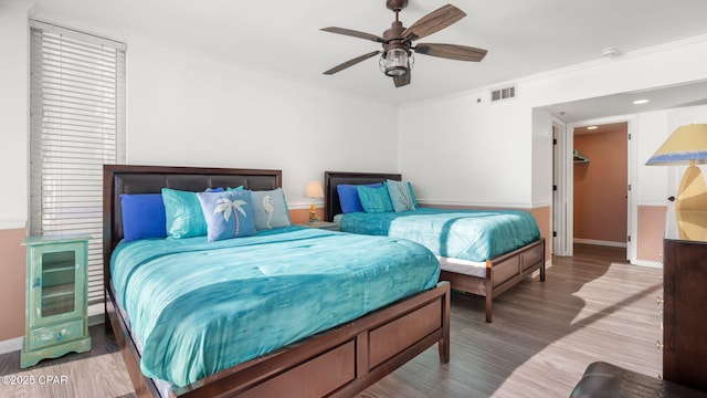 bedroom with ceiling fan, wood-type flooring, and ornamental molding