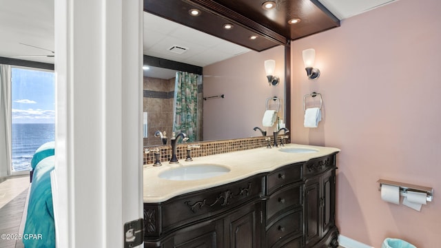 bathroom with decorative backsplash, vanity, a water view, and a shower with shower curtain