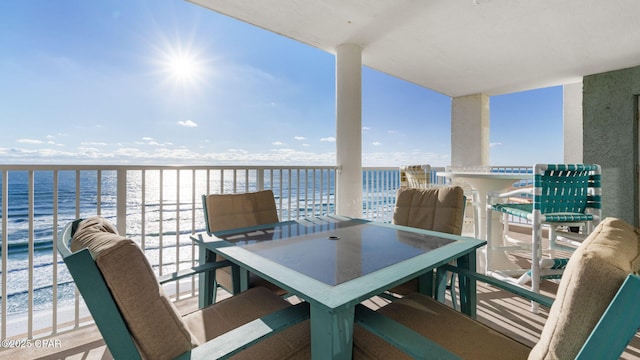 balcony featuring a water view and a beach view