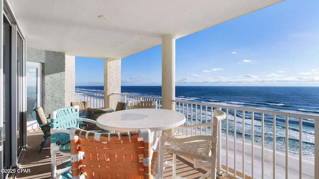 balcony featuring a water view and a beach view