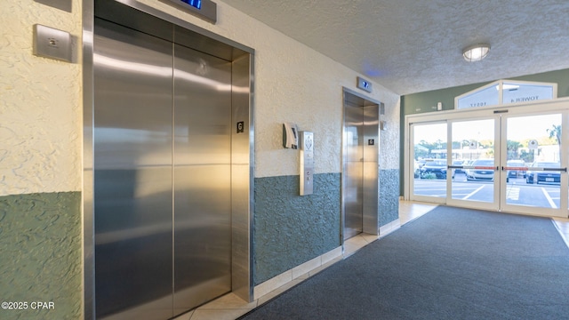 interior space featuring light colored carpet, lofted ceiling, a textured ceiling, and elevator