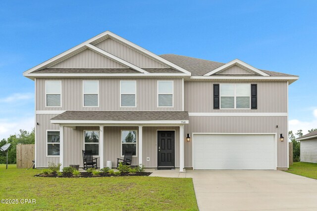 view of front facade featuring a porch, a garage, and a front lawn