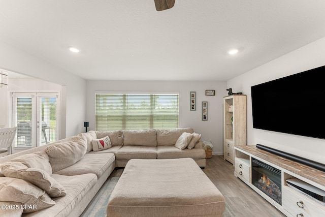 living room featuring light hardwood / wood-style flooring and ceiling fan