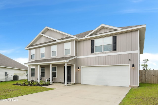 view of front of property featuring a garage, a front yard, and central AC