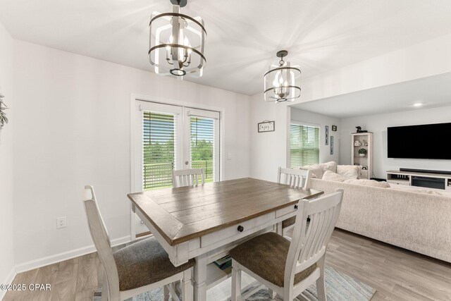 dining area featuring light wood-type flooring and an inviting chandelier