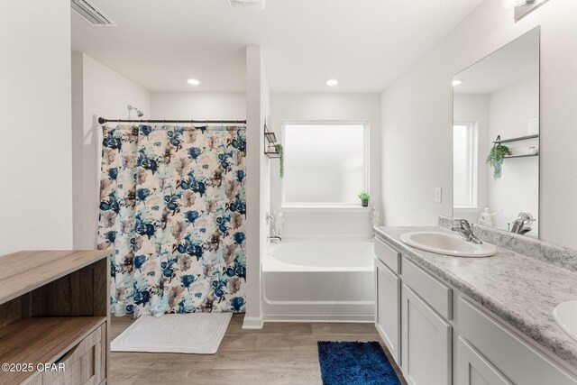 bathroom featuring hardwood / wood-style flooring, vanity, and separate shower and tub