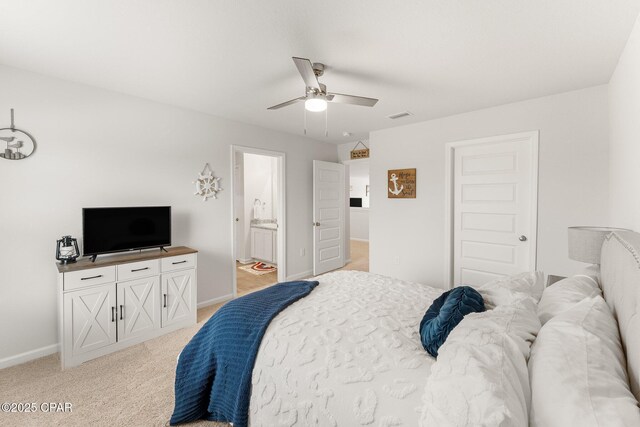 carpeted bedroom with ceiling fan and ensuite bathroom