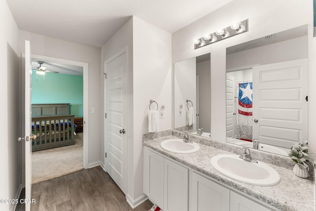 bathroom with hardwood / wood-style flooring, ceiling fan, and vanity