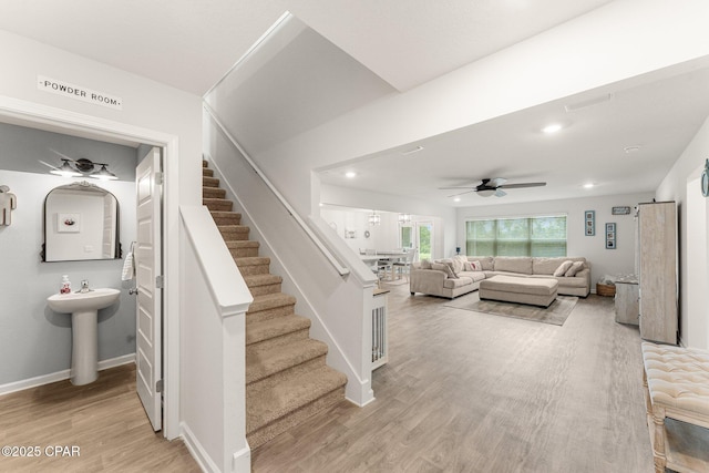 stairway with hardwood / wood-style flooring, ceiling fan, and sink