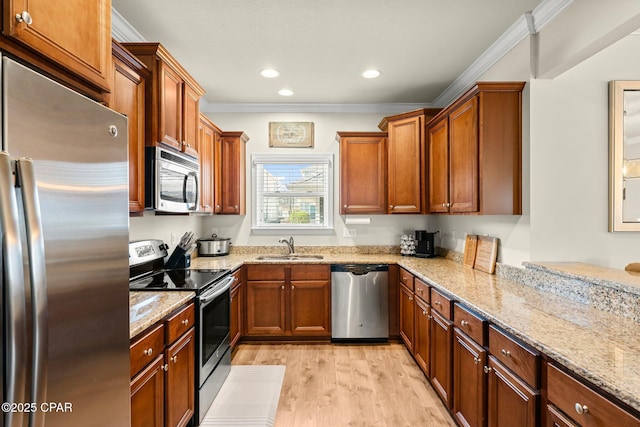 kitchen featuring light stone countertops, sink, appliances with stainless steel finishes, and ornamental molding