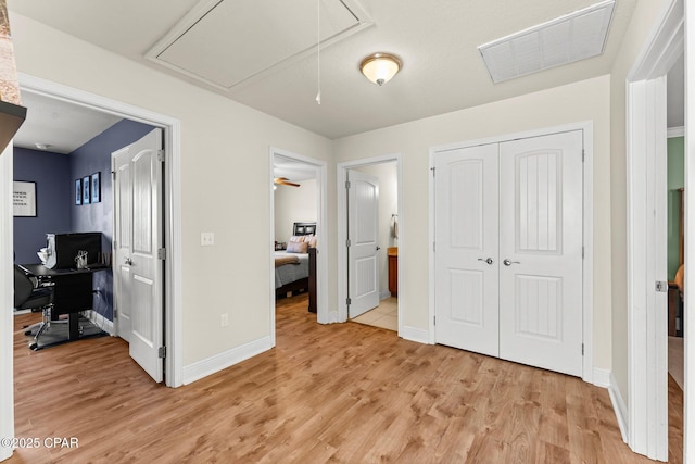 bedroom with light hardwood / wood-style floors, a closet, and ensuite bath