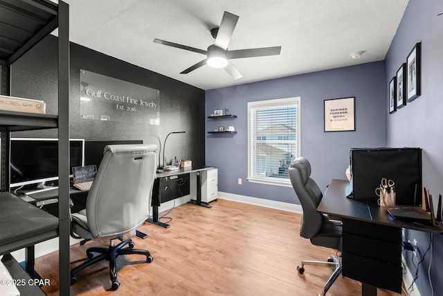 home office featuring a textured ceiling, light wood-type flooring, and ceiling fan