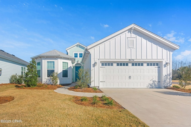 view of front of property with board and batten siding, an attached garage, driveway, and a front yard