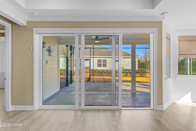 entryway with ceiling fan, baseboards, ornamental molding, and wood finished floors