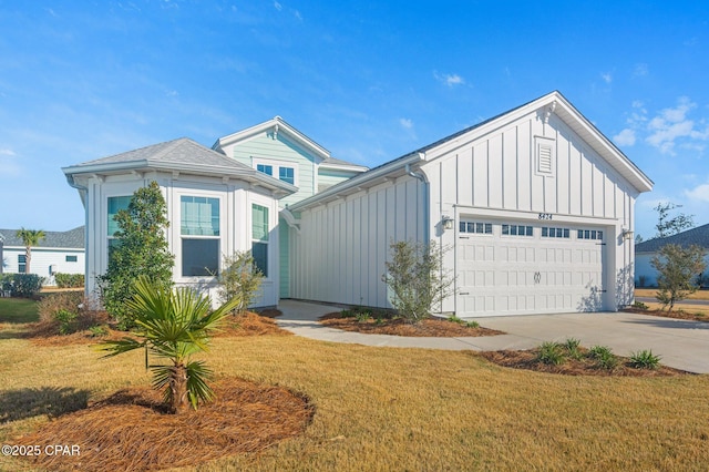 view of front of property with board and batten siding, a garage, driveway, and a front lawn