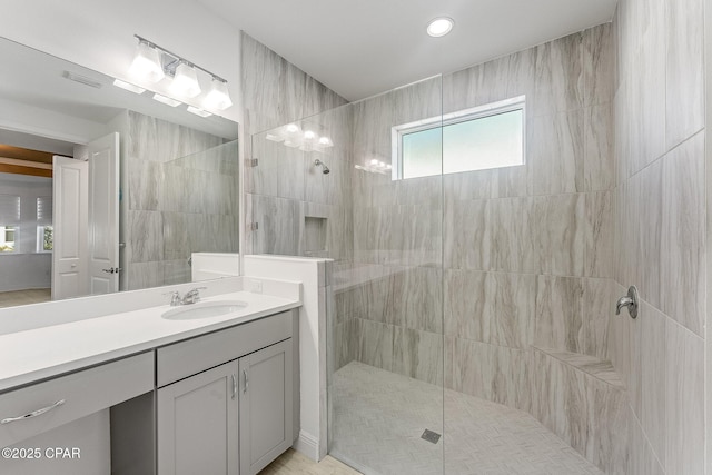 full bath featuring a walk in shower, vanity, recessed lighting, and visible vents