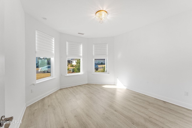 unfurnished room with baseboards and wood finished floors